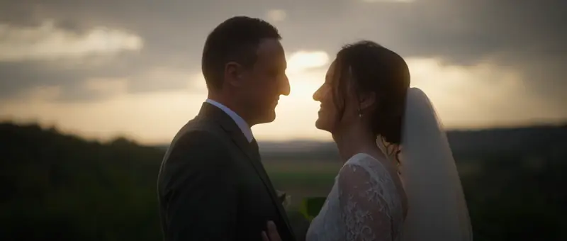 Les mariés se sourient au coucher du soleil, au-dessus de la campagne du Nord-Isère, au Château de Chapeau Cornu