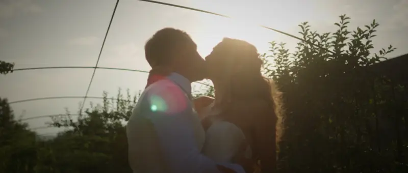 Baiser des mariés à contre-jour dans les jardins du Château de Saint-Bernard