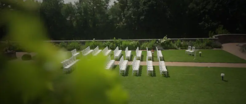 Les chaises blanches de la cérémonie dans un jardin clos du Château de Saint-Bernard