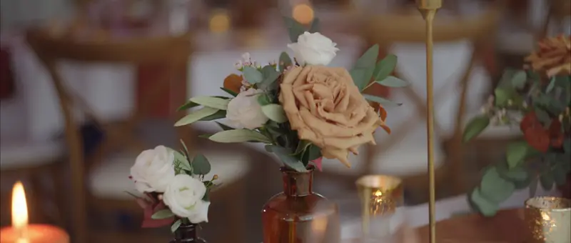 Bouquets de roses et bougies sur une table du dîner de mariage au Domaine de Sainte-Croix