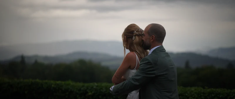 Les mariés enlacés au bord du jardin du Château de Chitry, face aux montagnes
