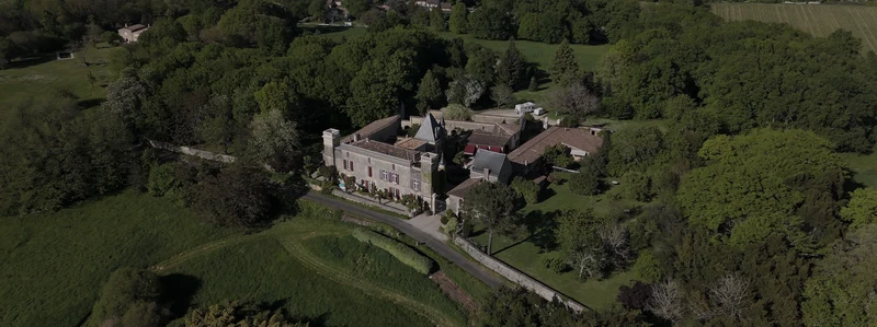 Le Château Sentout vu du drone au milieu des bois et des prairies de l'Entre-deux-Mers