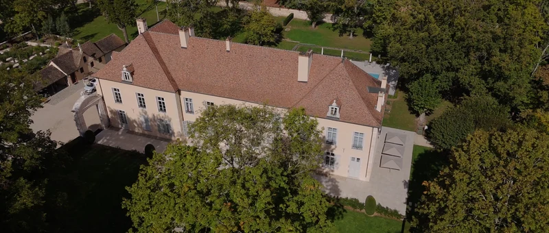 Le château de l'Abbaye de Maizières et ses toits de tuiles, vus du drone