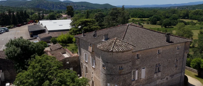 Le Château de Chaussy et sa tour vus du drone, avec les collines de l'Ardèche au loin