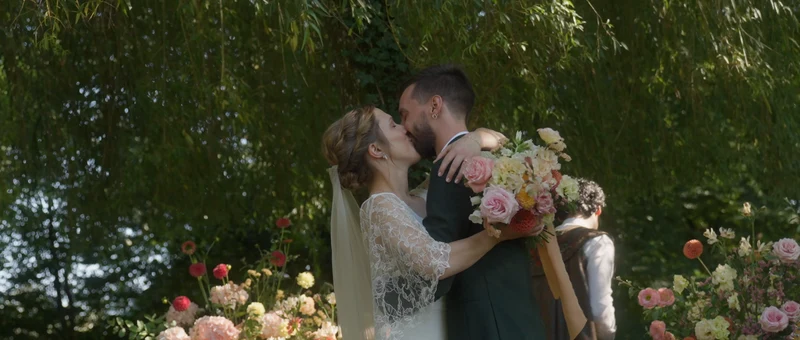 Le baiser des mariés sous les arbres du parc du Domaine de la Chartrognière, à la fin de la cérémonie