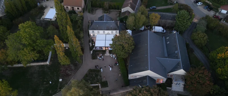 Le Domaine des Clos Vallées vu du ciel : la maison à fronton, la terrasse couverte et le parc