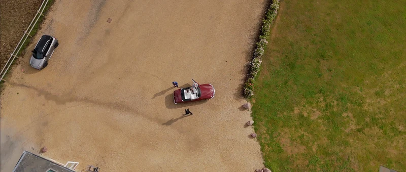La cour gravillonnée du Domaine de Valliquerville vue du drone, avec la voiture ancienne des mariés