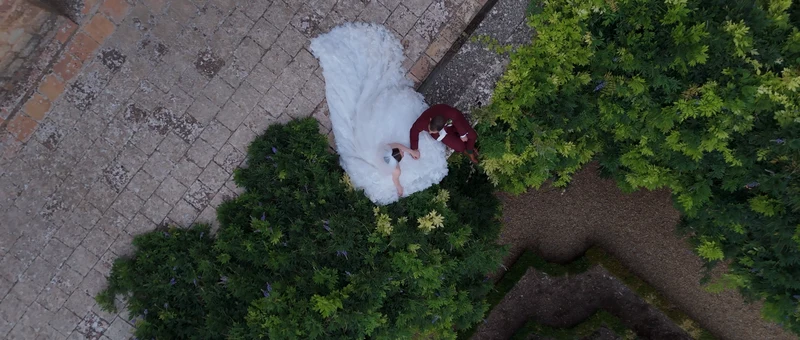 Les mariés allongés dans l'herbe du jardin de l'Abbaye de Fontfroide, vus du drone à la verticale