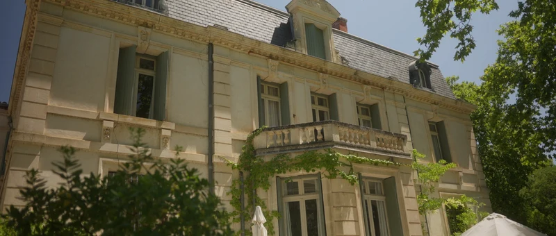 La façade du Château de Malmont, son balcon de pierre et ses lucarnes sous le toit d'ardoise