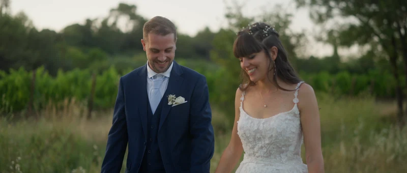 Les mariés souriants au bord des vignes du Château de Malmont