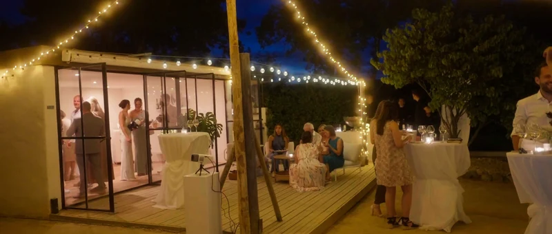 La terrasse de NOUS à la tombée de la nuit, sous les guirlandes lumineuses, devant la salle vitrée