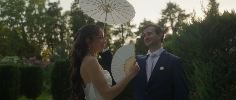 La mariée à l'ombrelle et le marié dans les jardins du Château de Paon, en fin de journée