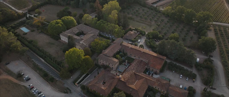 Le Château Sainte Roseline vu du drone : les bâtiments autour du cloître, entourés d'oliviers et de vignes
