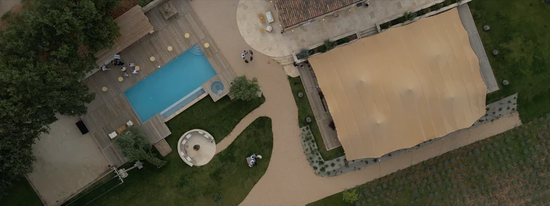 Le Domaine de Noé vu du drone : la piscine, la terrasse en bois et la tente de réception