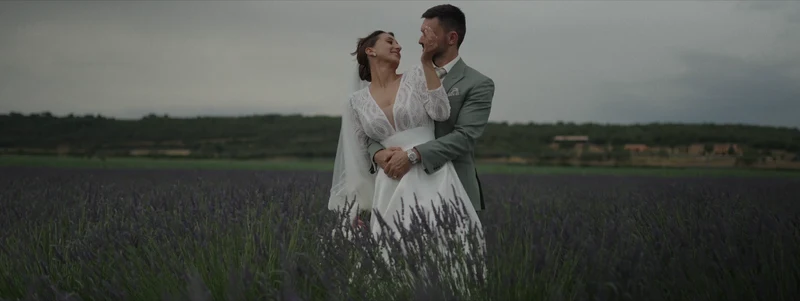 Les mariés enlacés dans un champ de lavande, au Domaine de Noé, sous un ciel d'orage