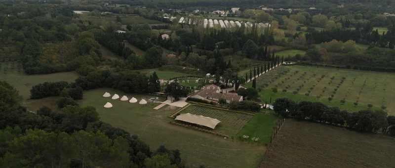 Le Mas des Costes vu du drone, entre l'allée de cyprès, les rangs de lavande et d'oliviers et la tente de réception
