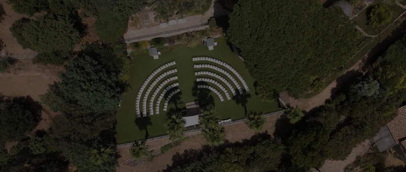 L'espace de cérémonie des Pins Penchés vu du dessus, chaises blanches en demi-cercle au milieu des pins