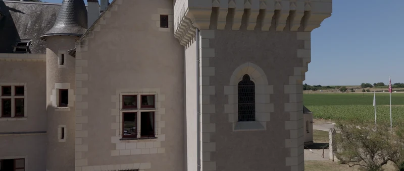 La tour et la façade de pierre blanche du Château de La Grille, face aux vignes