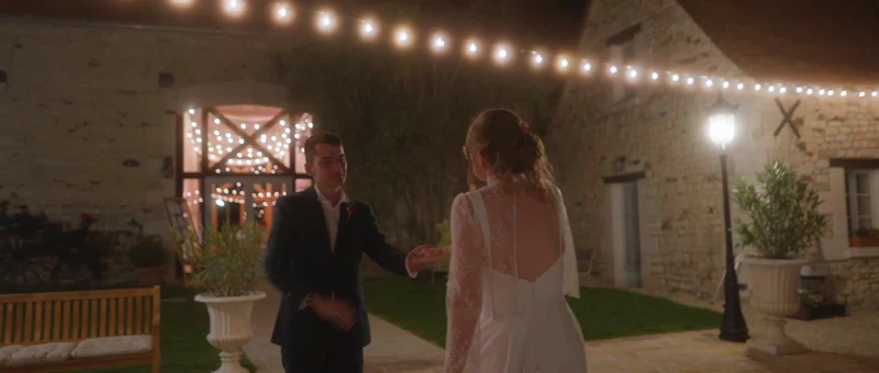 La cour du Domaine des 4 Saisons le soir, sous les guirlandes lumineuses, avec les mariés au centre