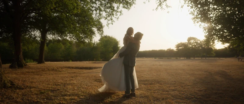 Le marié soulève la mariée dans le parc du Domaine Le Chéry, à contre-jour
